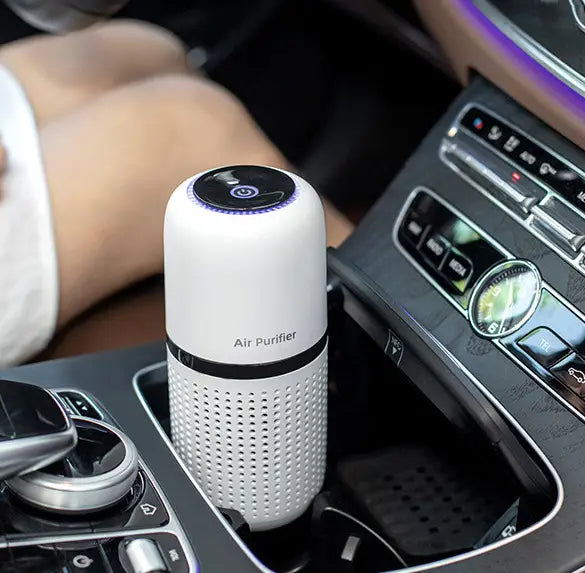 Cylindrical white car air purifier in cup holder using negative ion technology to eliminate formaldehyde