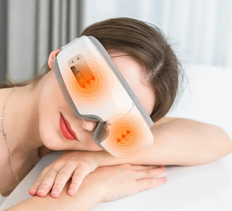 Eye massager with glowing orange heating elements for soothing hot compress therapy.